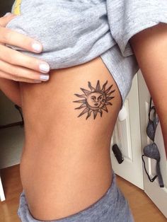 a woman with a sun tattoo on her stomach