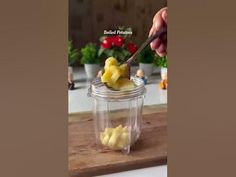 a person is cutting up some food in a jar