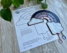 a piece of stained glass sitting on top of a wooden table next to a plant