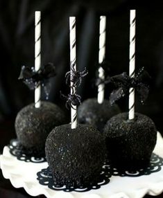 black cake pops are on a white plate