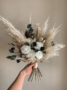 a hand holding a bouquet of white flowers