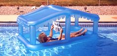 a woman laying on top of a blue inflatable pool with a life raft