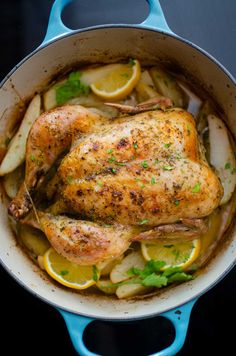 a chicken in a pan with lemons and parsley