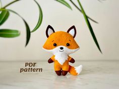 a small stuffed fox sitting on top of a table