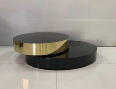 two black and gold coffee tables sitting on top of a white tile floor next to each other