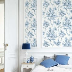 a bedroom with two blue and white wallpapers