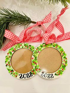 two christmas ornament ornaments with ribbons on them