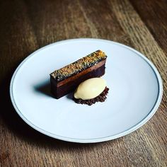 a piece of cake sitting on top of a white plate next to a scoop of ice cream