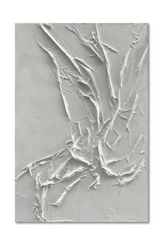 an abstract painting with white paint and branches on the wall in front of a gray background