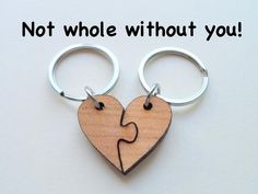 two heart shaped wooden keychains with the words not whole without you on them