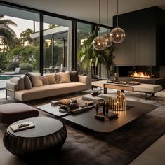 a living room with couches and tables in front of large windows overlooking the pool