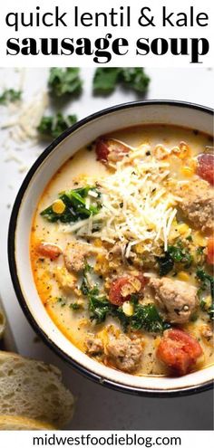 a white bowl filled with sausage and kale soup on top of a table next to bread