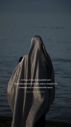 a person wrapped in a blanket looking out at the water with a quote written on it