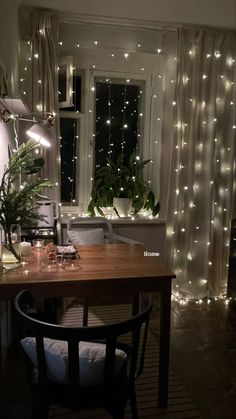 a dining room table with lights on the windowsill and plants in pots next to it