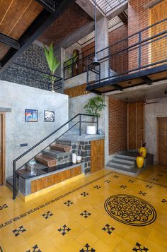 a yellow tiled floor with stairs leading up to the second floor and an iron handrail