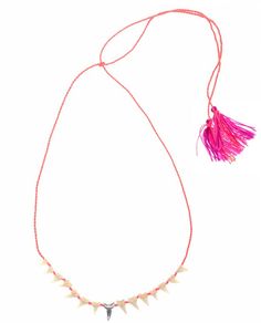 a pink necklace with spikes and tassels