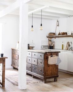 an old fashioned kitchen with wooden cabinets and white walls is pictured in this image from the inside