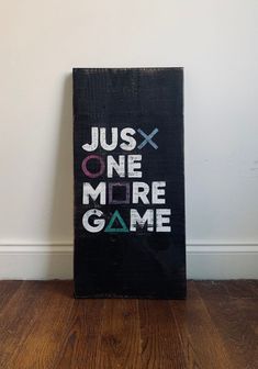 a wooden sign that says just one more game on the side of a white wall