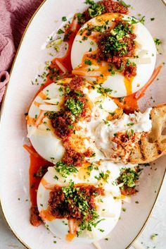 an egg dish on a white plate topped with sour cream and garnished with parsley