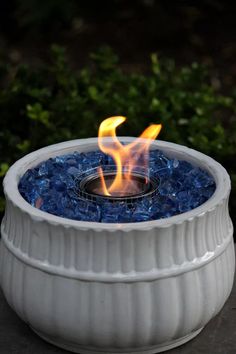 an outdoor fire pit with blue glass pebbles