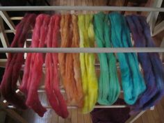 there are many different colors of yarn on the rack