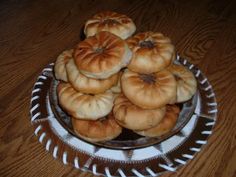 a plate full of bread buns sitting on a table