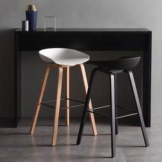 two black and white stools sitting next to each other in front of a counter