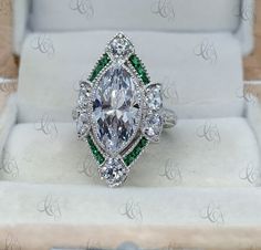 Vintage Cocktail Ring, 3.00 Ct Bezel Set Marquise and Emerald Antique Art Deco Engagement Ring, Milgrain Ring, Victorian Style Ring Main Stone Shape: Marquise Main Stone Weight: 3.00CT Main Stone Colour: White Main Stone Type: Cubic Zirconia Primary Stone Shape: Round & Baguette Primary Stone Colour: White & Green Primary Stone Type: Cubic Zirconia Metal : 925 Sterling Silver Or 935 Argentium Silver Please contact us for Different Metal Color & Purity. ✱ ETSY SHOP : https://www.etsy. Gia Certified Marquise Cut Jewelry For Gift, White Emerald Ring With Center Stone For Gift, Gia Certified Marquise Rings As Gift, Anniversary Marquise Emerald Ring With Accent Stones, Oval White Emerald Anniversary Ring, White Emerald Ring With Halo Setting As Gift, White Oval Emerald Anniversary Ring, Marquise Emerald Ring With Center Stone For Anniversary, Heirloom Marquise Emerald Ring For Anniversary