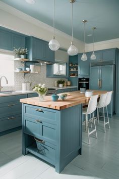 a kitchen with blue cabinets and wooden counter tops, white chairs and an island in the middle