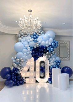 balloons are arranged around the number 40 in front of a chandelier and mirror