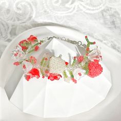 a close up of a bracelet on a plate with flowers and leaves around it,