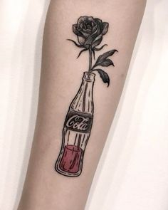 a rose in a coke bottle tattoo on the arm