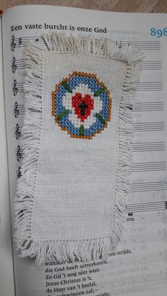 an open book with a cross stitch pattern on it