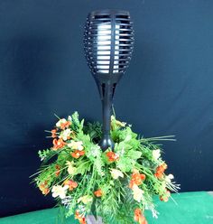 a vase with flowers in it and a black hair comb on the top of it