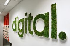 the word digital is made up of green grass and letters that spell out it's name