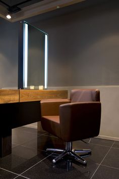 a brown chair sitting in front of a mirror