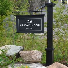 a sign for cedar lane in front of some rocks