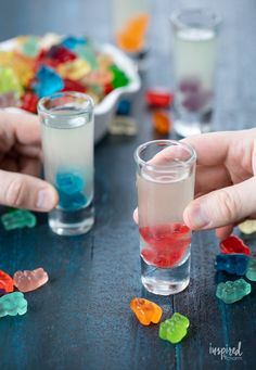 three glasses filled with gummy bears sitting on top of a table