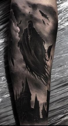 a man's leg with a black and white tattoo on it, featuring an image of a wizard flying through the sky