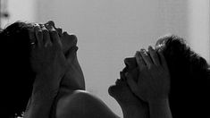 two women laying on the floor with their hands covering their faces