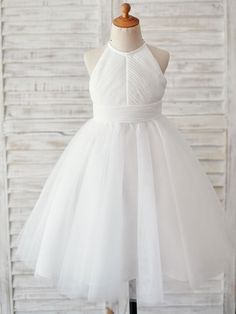 a white flower girl dress on a mannequin