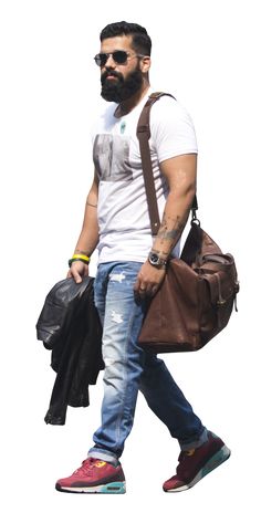 a man with a beard and glasses carrying a brown bag while walking across a white background