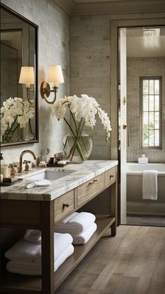 a bathroom with two sinks, mirrors and towels on the counter in front of it