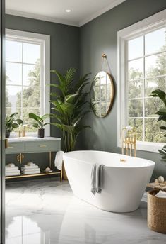 A spacious bathroom with a Sherwin Williams Evergreen Fog vanity featuring gold fixtures, a marble countertop, light wood flooring, and a freestanding white bathtub near a large window. White Bathtub, Elegant Bathroom Design, Gold Fixtures, Light Wood Floors, Large Window, Marble Countertop