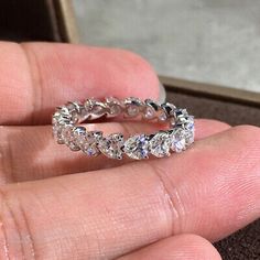 a person is holding a ring in their hand, with diamonds on the inside of it