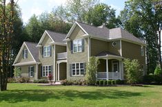 a large green house sitting in the middle of a lush green field with lots of trees