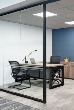 an office with glass walls and black chairs