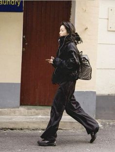 a woman walking down the street with a handbag