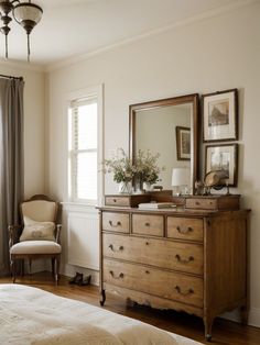 a bedroom scene with focus on the dresser and chair, window to the side area