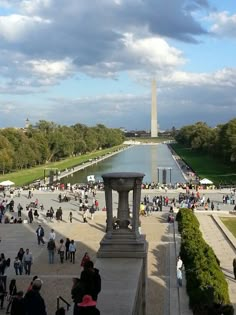 people are walking around in front of the washington monument and reflecting pool with water on it